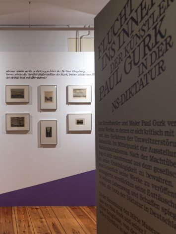 Blick in die Ausstellung "Flucht ins Innere". Zu sehen ist eine Wand, auf der Aquarelle und Gouache-Zeichnungen von Paul Gurk hängen.