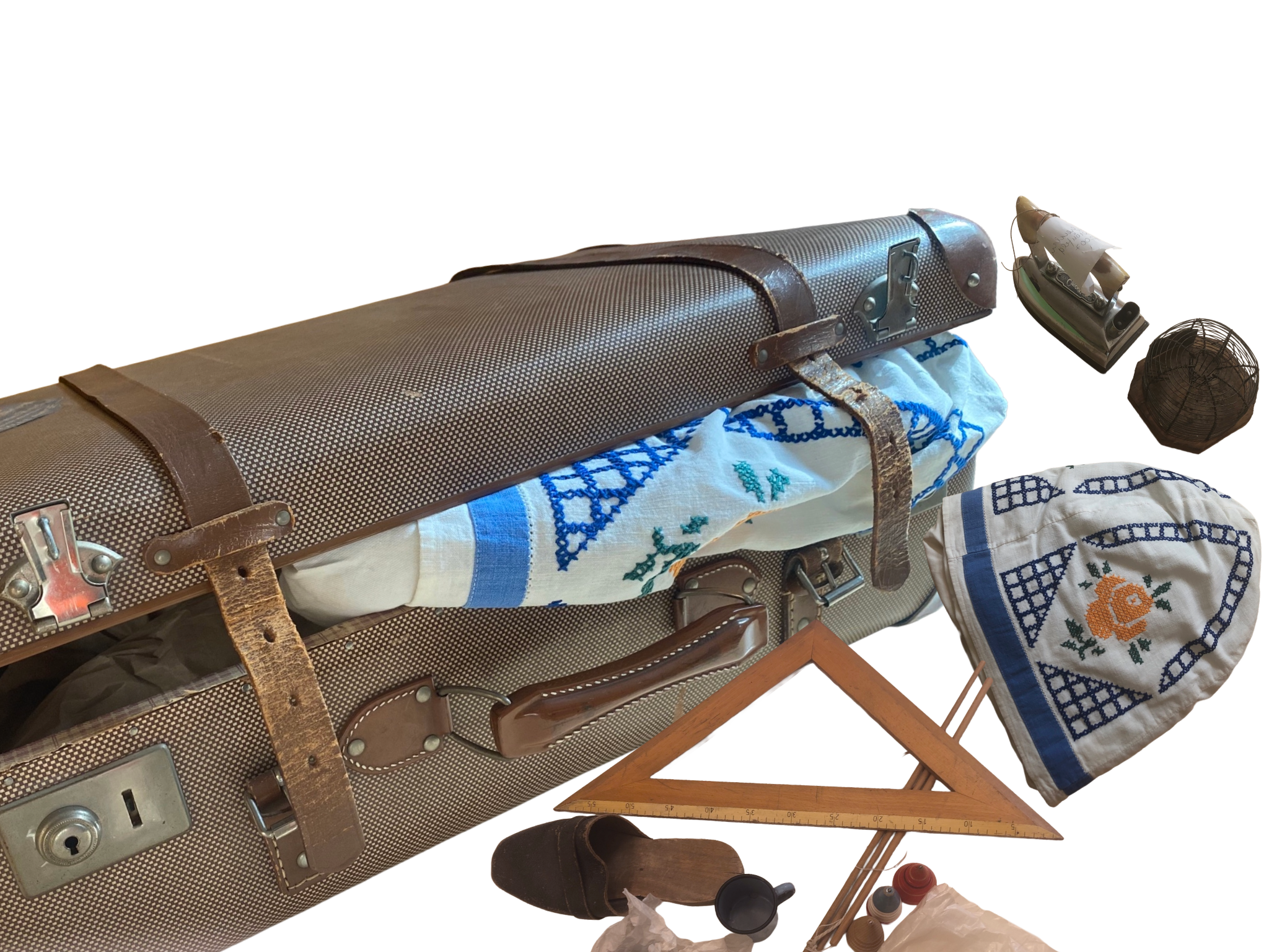 Aus einem Koffer quellen allerlei Museums- und Sammlungsobjekte, wie ein altes Geodreieck, Holzschlappen, ein altes Bügeleisen und eine Kaffeemütze.