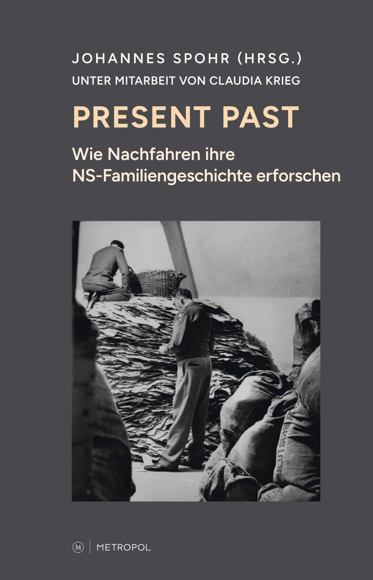 Das Buchcover von "Present Past" zeigt unter dem Titel eine schwarz-weiße, historische Fotografie. Mehrere Menschen stehen in einem Raum voller Archivalien, die sich im Zimmer turmartig häufen.